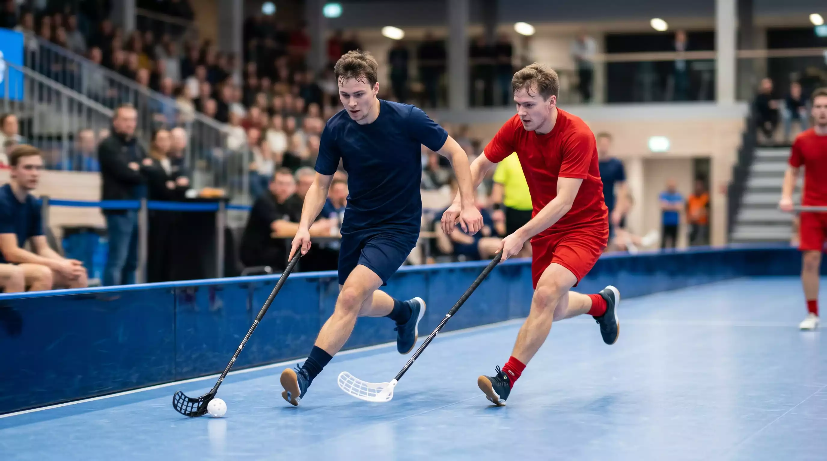 Schnelle Spielszene in einer NLA-Unihockey-Partie mit Spielern im vollen Tempo