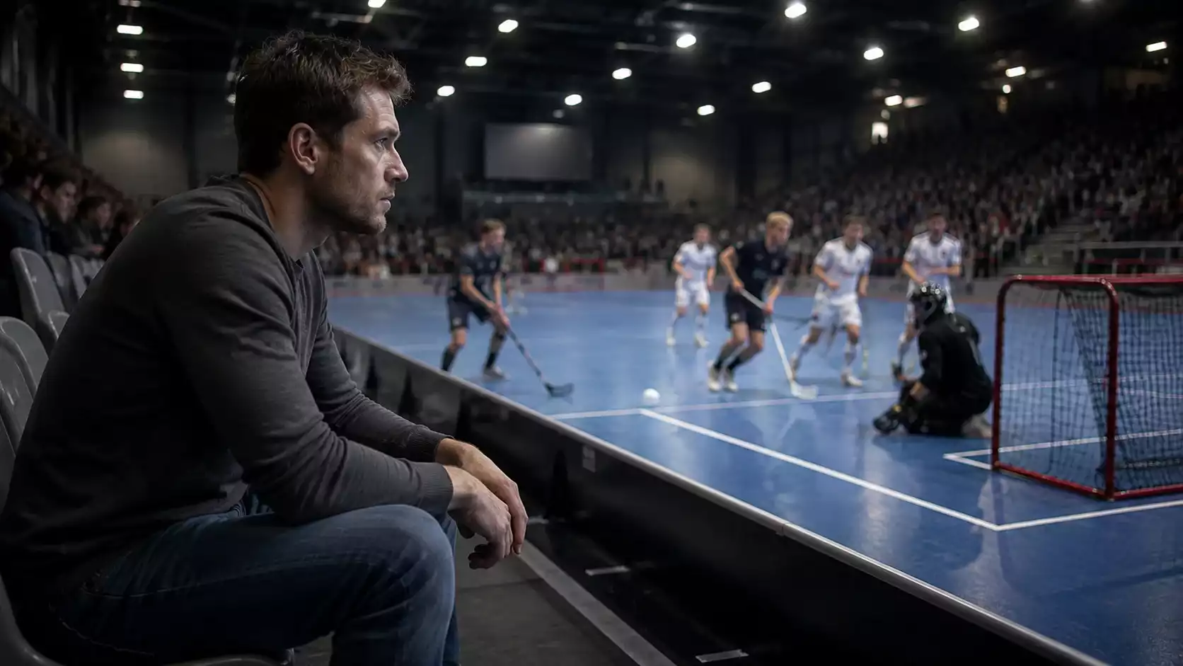 Nachdenklicher Unihockey-Zuschauer mit Smartphone in der angespannten Schlussphase eines Spiels