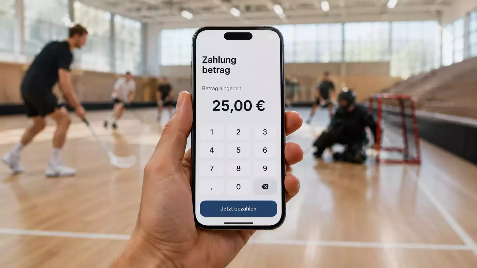 Hand bezahlt mobil per App auf dem Smartphone vor einer Sporthalle
